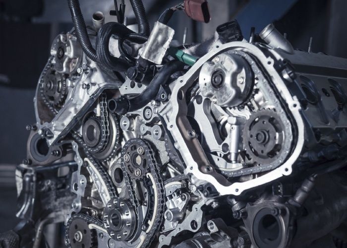 Öppen motor med synliga kamkedjor, kugghjul och spännare